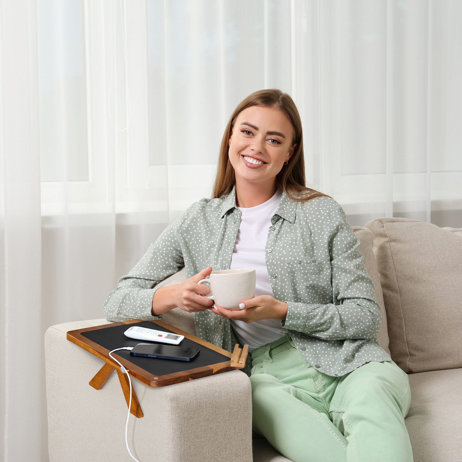 Woman relaxing on a sofa using the acacia arm tray