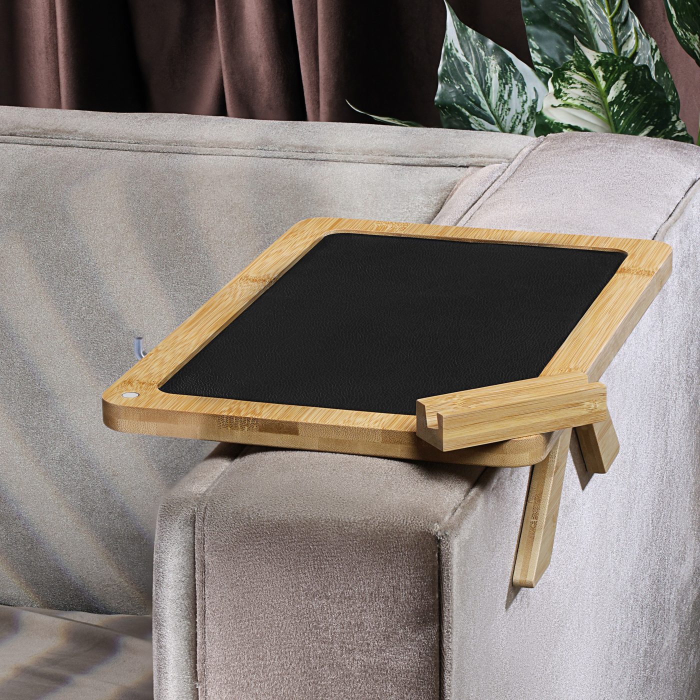 Bamboo couch arm tray clamped on a sofa armrest