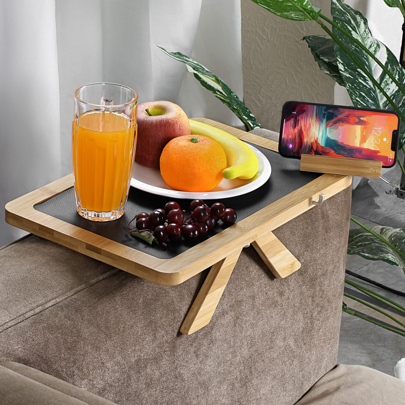 Bamboo tray holding breakfast, juice, and a phone
